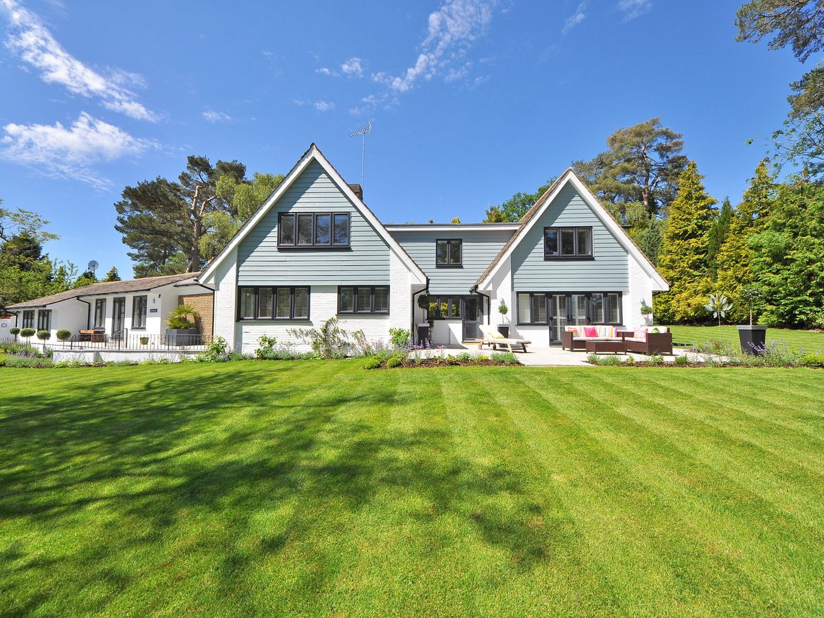 Bright suburban home with blue-gray siding, white brick, and dark-framed windows
